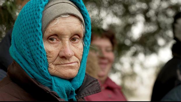 Pensioners in the newly liberated village of Novomykolaivka in the Kherson region wait for their first pension in eight months. Pictures via Paraic O'Brien/Channel4 News.